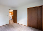 Thumbnail 7 of 13 - a bedroom with a closet and a door to a kitchen. Fargo, ND Brookfield Apartments