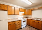 Thumbnail 6 of 13 - a kitchen with white appliances and wooden cabinets. Fargo, ND Brookfield Apartments