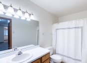 Thumbnail 22 of 33 - a bathroom with a large mirror and a sink and a toilet. Fargo, ND Brownstone Apartments