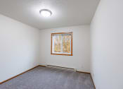 Thumbnail 19 of 33 - a bedroom with a window and carpet. Fargo, ND Brownstone Apartments