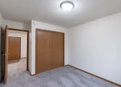 Thumbnail 20 of 33 - an empty living room with carpet and a door to a bedroom. Fargo, ND Brownstone Apartments