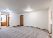 Thumbnail 16 of 33 - a dining room with a carpeted floor and a door to a bathroom. Fargo, ND Brownstone Apartments
