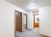 Thumbnail 21 of 33 - an empty room with two doors and a bathroom. Fargo, ND Brownstone Apartments