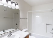 Thumbnail 32 of 33 - a bathroom with a mirror and a sink and a shower. Fargo, ND Brownstone Apartments