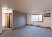 Thumbnail 24 of 33 - the living room of an empty house with a large window. Fargo, ND Brownstone Apartments