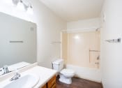 Thumbnail 39 of 41 - a bathroom with a toilet and a sink and a mirror. Fargo, ND Carlton Place Apartments