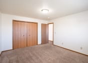 Thumbnail 36 of 41 - a bedroom  with a carpeted floor and a closet. Fargo, ND Carlton Place Apartments