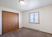 Thumbnail 37 of 41 - a bedroom with a window and a closet. Fargo, ND Carlton Place Apartments