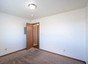 Thumbnail 38 of 41 - a bedroom with carpeted floor and a door to a hallway. Fargo, ND Carlton Place Apartments