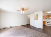 Thumbnail 34 of 41 - an empty living room with a ceiling fan and a kitchen. Fargo, ND Carlton Place Apartments