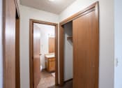 Thumbnail 11 of 15 - a bathroom with two doors and a closet with a sink and a mirror. Fargo, ND Cedar Pointe Apartments