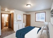 Thumbnail 3 of 15 - a bedroom with a white bed and a blue blanket. Fargo, ND Cedar Pointe Apartments
