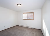 Thumbnail 14 of 42 - an empty room with carpet and a window. Fargo, ND Country Club Apartments