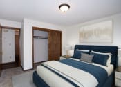 Thumbnail 3 of 42 - a bedroom with a bed and a closet and a door to a bathroom.  Fargo, ND Country Club Apartments