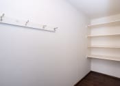 Thumbnail 18 of 42 - a room with white walls and shelves and a white shelf on the wall. Fargo, ND Country Club Apartments