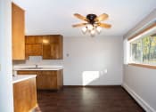 Thumbnail 12 of 42 - an empty kitchen with a ceiling fan and a window. Fargo, ND Country Club Apartment