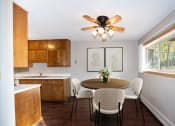 Thumbnail 2 of 42 - a kitchen with a table and chairs and a ceiling fan. Fargo, ND Country Club Apartments