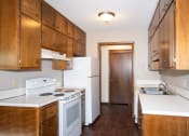 Thumbnail 10 of 42 - an empty kitchen with white appliances and wooden cabinets. Fargo, ND Country Club Apartments
