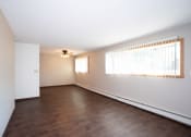 Thumbnail 8 of 42 - an empty living room with wood floors and a large window. Fargo, ND Country Club Apartments