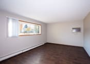 Thumbnail 9 of 42 - an empty living room with wood floors and a window. Fargo, ND Country Club Apartments