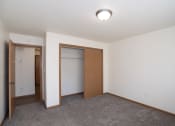 Thumbnail 36 of 42 - an empty room with a closet and a door to a bathroom. Fargo, ND Country Club Apartments