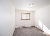 Thumbnail 37 of 42 - an empty room with carpet and a window. Fargo, ND Country Club Apartments