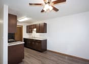 Thumbnail 34 of 42 - an empty kitchen with wooden cabinets and a ceiling fan. Fargo, ND Country Club Apartments