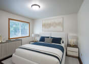 Thumbnail 3 of 18 - a bedroom with a bed and two night stands and a window. Fargo, ND Crown Court 1 Apartments