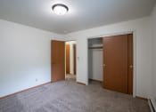 Thumbnail 17 of 18 - a bedroom with a closet and a door to a bathroom.  Fargo, ND Crown Court 1 Apartments