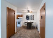Thumbnail 2 of 18 - a kitchen and dining room with a small table and a ceiling fan. Fargo, ND Crown Court 1 Apartments