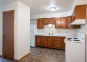 Thumbnail 15 of 18 - an empty kitchen with white appliances and wooden cabinets