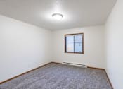 Thumbnail 16 of 23 - a bedroom with carpet and a window. Fargo, ND Flagstone Apartments