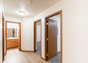 Thumbnail 20 of 23 - a living room with a door to a bathroom and a mirror. Fargo, ND Flagstone Apartments