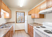 Thumbnail 13 of 23 - an empty kitchen with a stove refrigerator and sink. Fargo, ND Flagstone Apartments