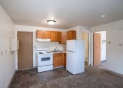 Thumbnail 4 of 7 - an empty kitchen with white appliances and wooden cabinets.Fargo, ND Forest Avenue Apartments