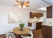 Thumbnail 2 of 13 - a kitchen and dining room with a table and chairs and a ceiling fan. Fargo, ND Hartford Apartments