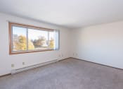 Thumbnail 5 of 13 - the living room of an empty house with a large window. Fargo, ND Hartford Apartments