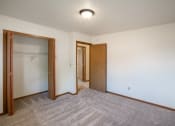 Thumbnail 11 of 13 - a bedroom of an empty apartment with a door to the closet. Fargo, ND Hunters Run 2 Apartments