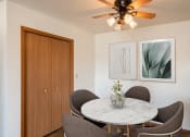 Thumbnail 3 of 13 - a dining room with a marble table and chairs and a ceiling fan. Fargo, ND Hunters Run 2 Apartments