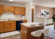 Thumbnail 2 of 13 - a kitchen with a island and a sink and a black dishwasher. Fargo, ND Hunters Run 2 Apartments
