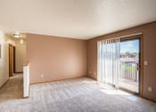 Thumbnail 6 of 13 - an empty living room with a sliding glass door to a balcony. Fargo, ND Hunters Run 2 Apartments