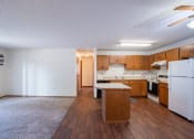 Thumbnail 7 of 14 - a kitchen and living room with white appliances. Fargo, ND Kentwood Manor Apartments