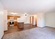 Thumbnail 8 of 14 - the living room and kitchen of an apartment with white walls and wood flooring. Fargo, ND Kentwood Manor Apartments