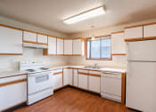Thumbnail 19 of 49 - an empty kitchen with white appliances and white cabinets. West Fargo, ND Lake Crest Apartments
