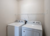 Thumbnail 21 of 49 - an empty laundry room with two washes and a dryer. West Fargo, ND Lake Crest Apartments