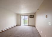 Thumbnail 17 of 49 - an empty living room with a door to a patio. West Fargo, ND Lake Crest Apartments 21e