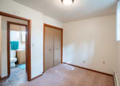 Thumbnail 8 of 11 - an empty room with a door to a bathroom and a toilet. Fargo, ND Luxford Apartments