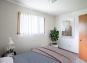 Thumbnail 11 of 11 - a bedroom with a bed and a plant. Fargo, ND Luxford Apartments
