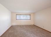 Thumbnail 15 of 20 - a spacious living room with carpet and a window. Fargo, ND Martha Alice Apartments