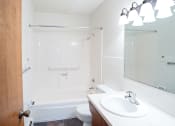 Thumbnail 18 of 20 - a bathroom with a sink and a shower and a toilet. Fargo, ND Martha Alice Apartments